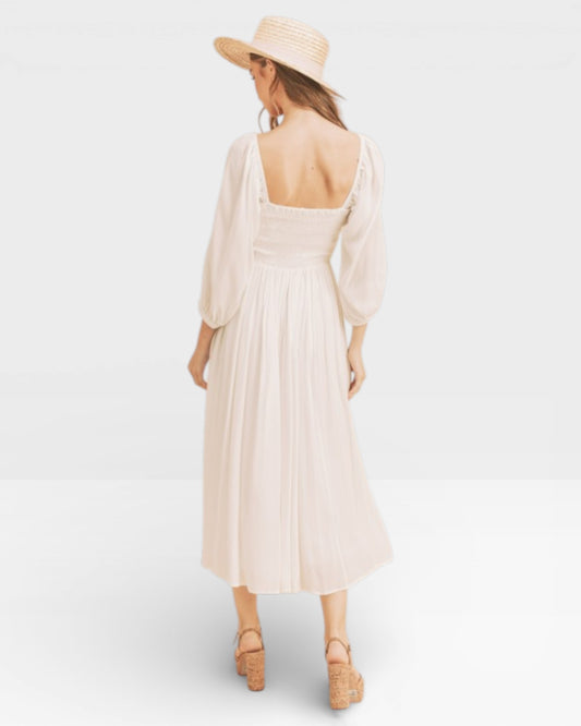 Woman wearing a beige dress and hat on a white background