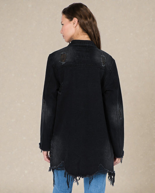 Black distressed denim jacket worn by a person on a beige background