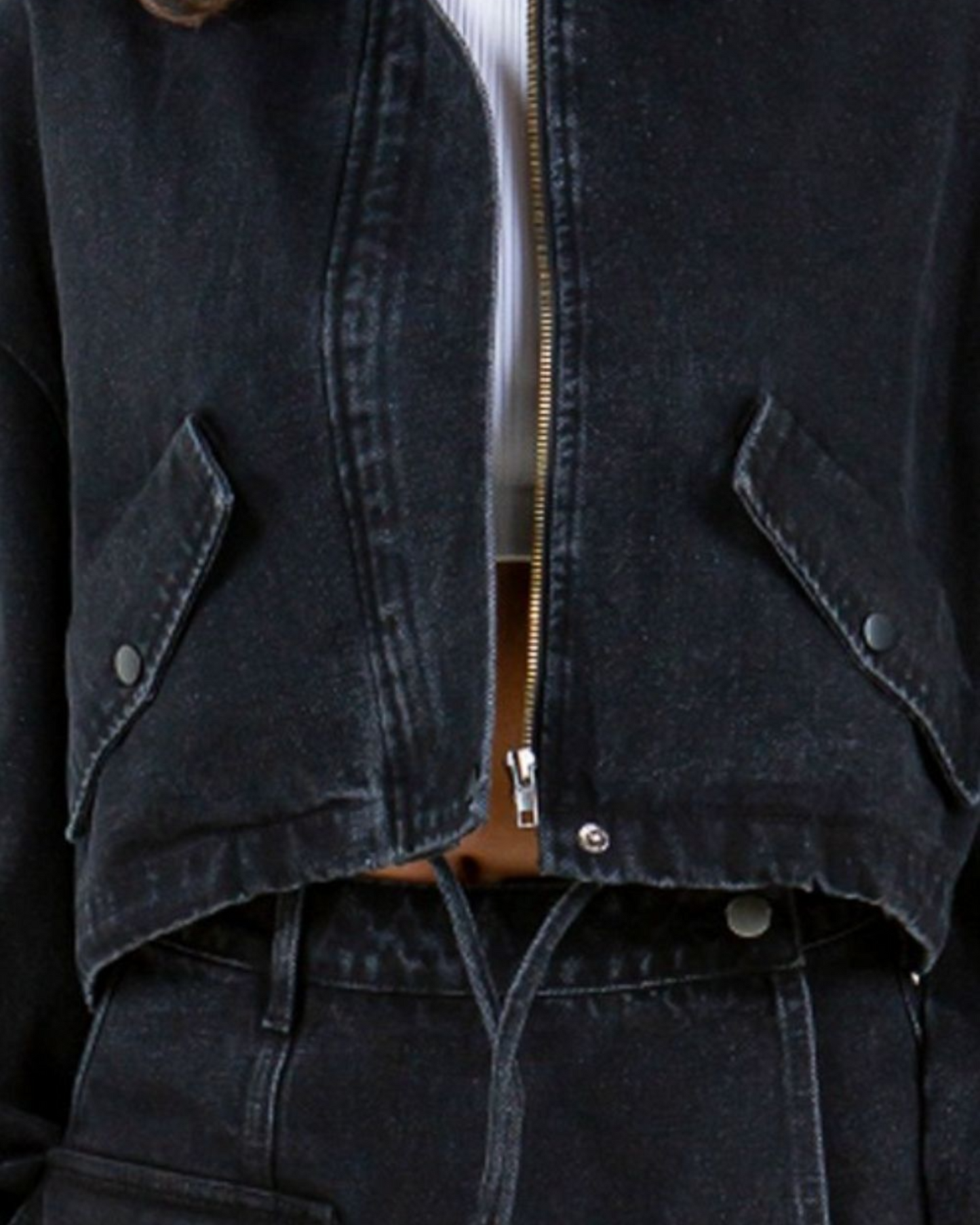 Close-up of a dark denim jacket with a zipper