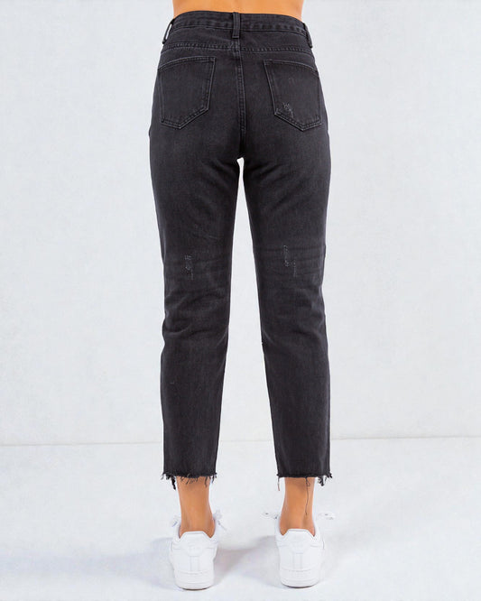 Black jeans worn by a person on a white background