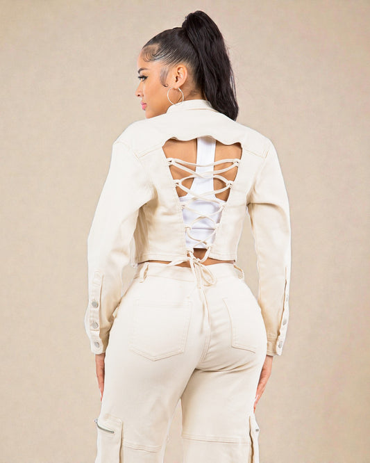 Person wearing a cream-colored outfit with a backless top and matching pants on a beige background