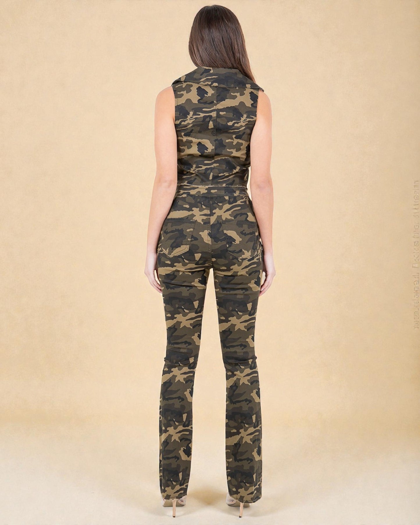 Woman wearing a camouflage jumpsuit against a beige background