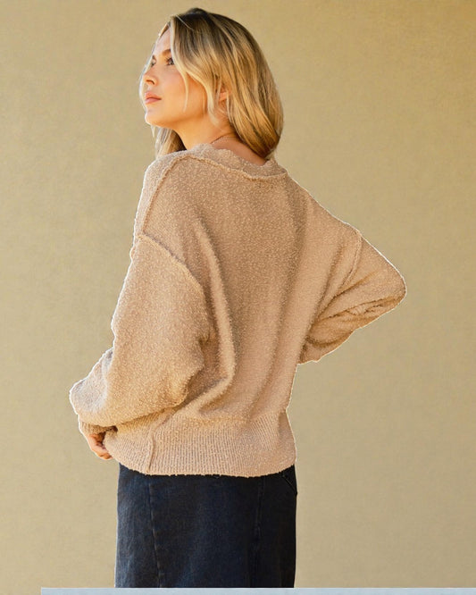 Woman wearing a beige sweater against a beige background