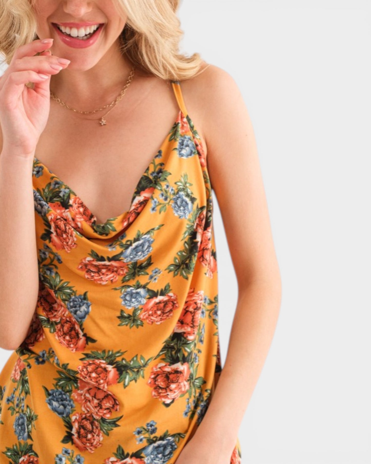 Woman wearing a yellow floral dress on a plain background