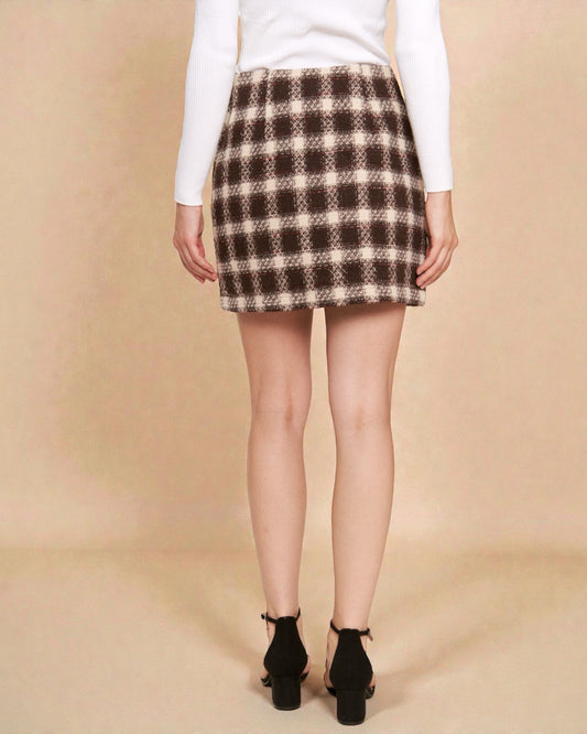 Person wearing a plaid skirt on a beige background