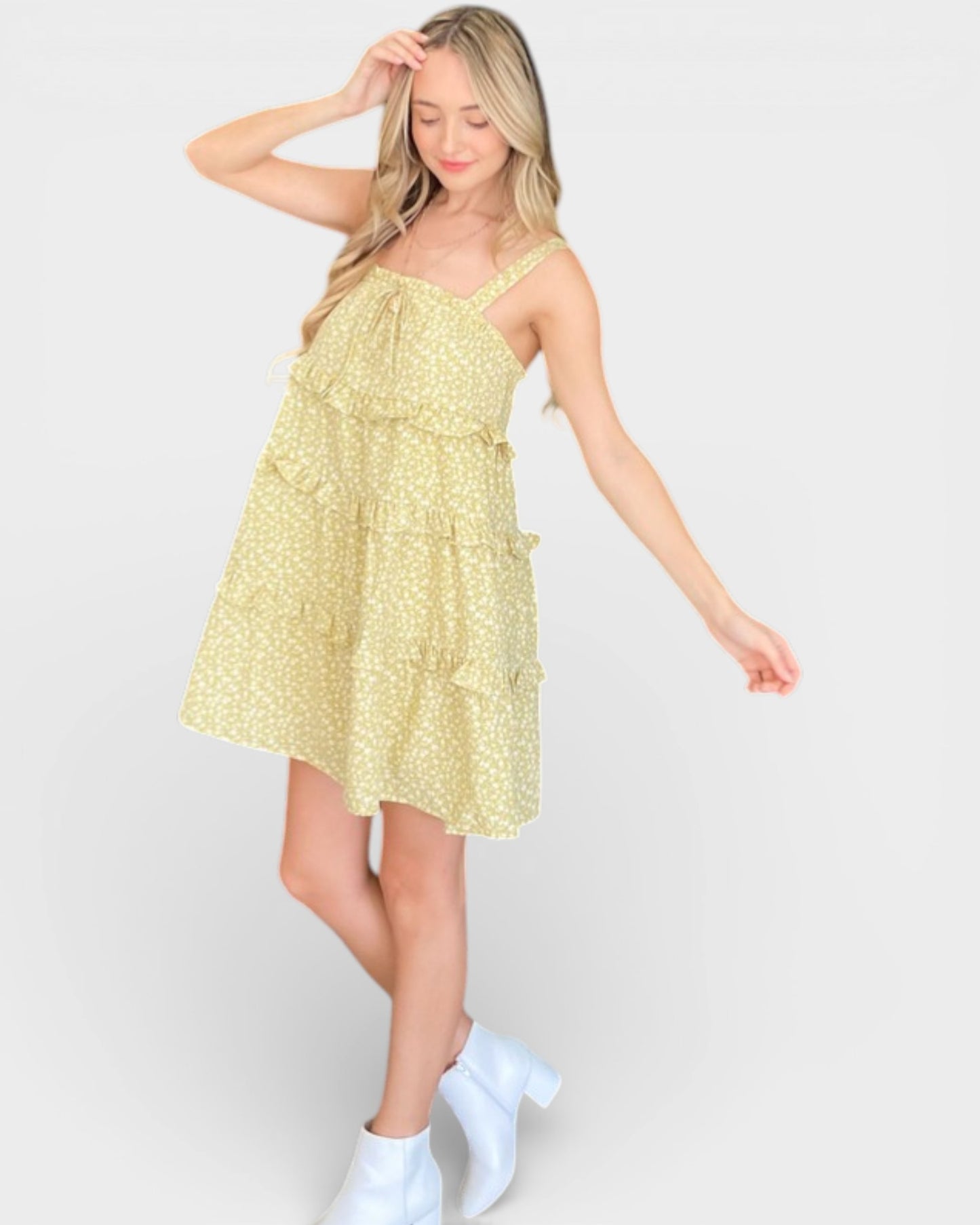 Woman wearing a yellow floral dress against a white background