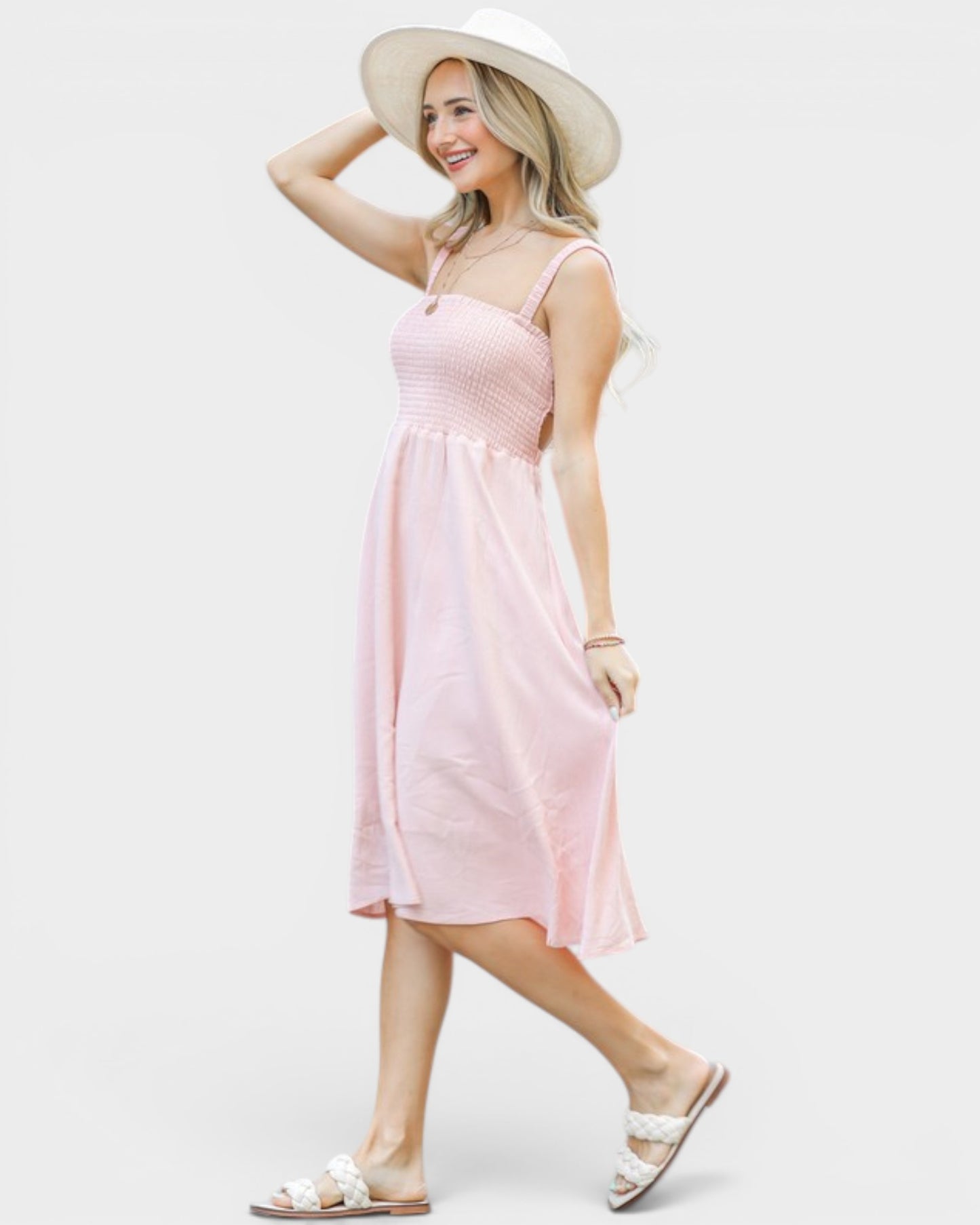 Woman wearing a pink dress and white hat on a white background