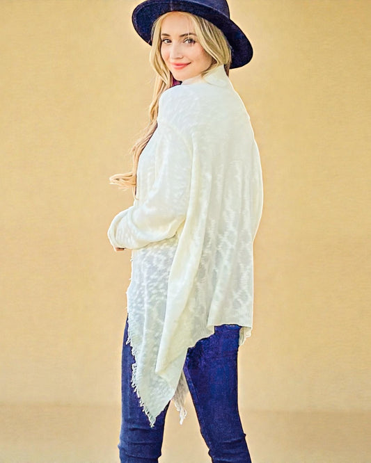 Woman wearing a white shawl and blue hat on a beige background