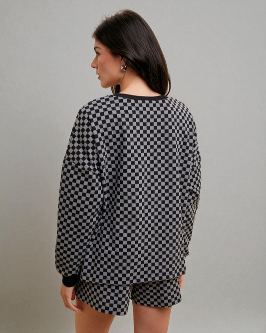 Person wearing a black and white checkered outfit on a gray background