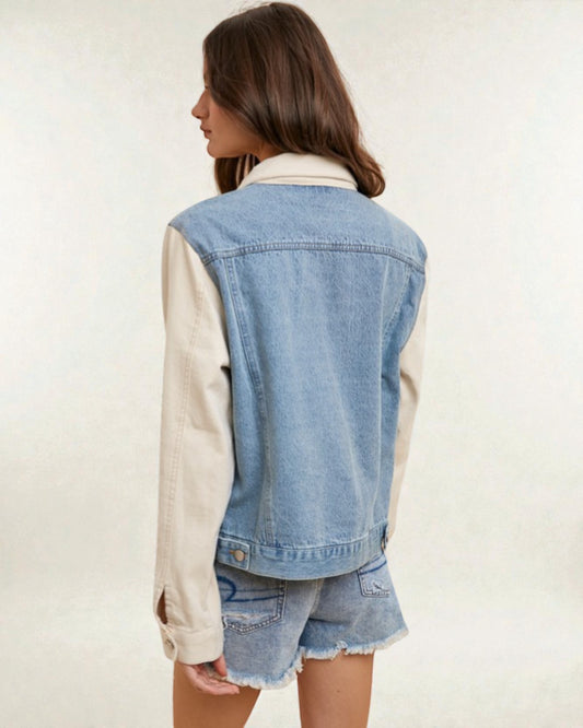 Person wearing a denim vest over a white shirt with shorts on a plain background