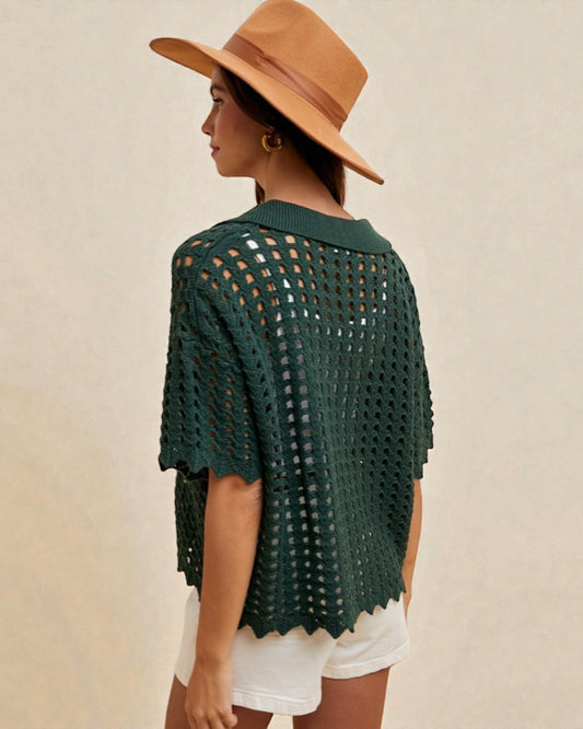 Woman wearing a green crochet top and white shorts with a brown hat on a beige background