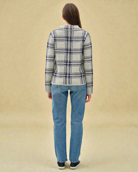 Person wearing a plaid shirt and jeans on a beige background