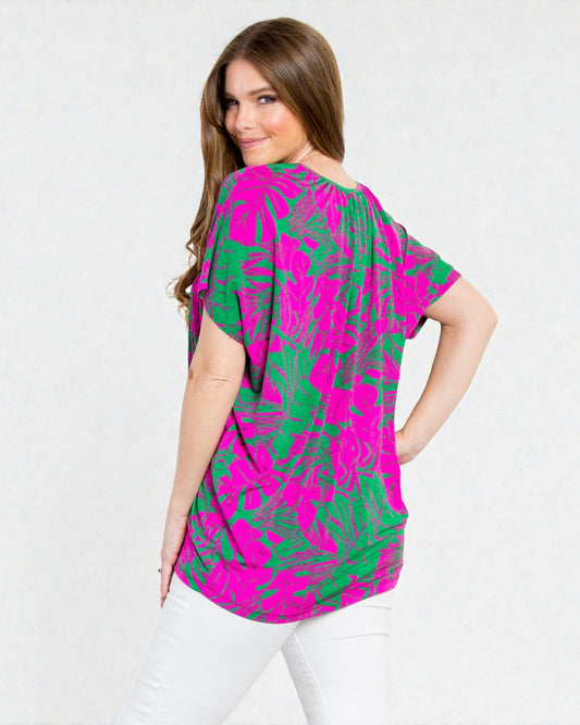 Woman wearing a pink and green patterned blouse on a white background