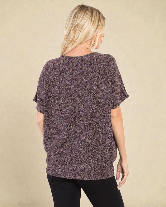 Woman wearing a textured purple top against a beige background