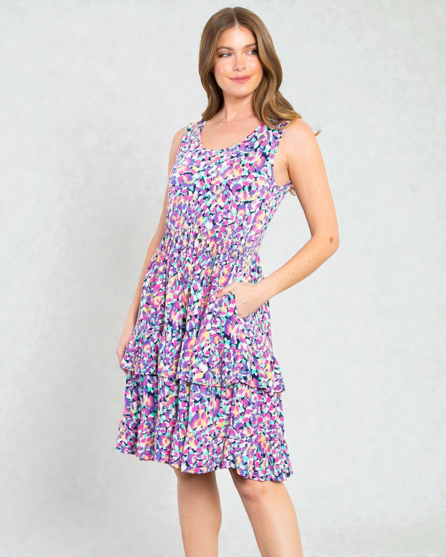 Woman wearing a colorful patterned dress on a plain background