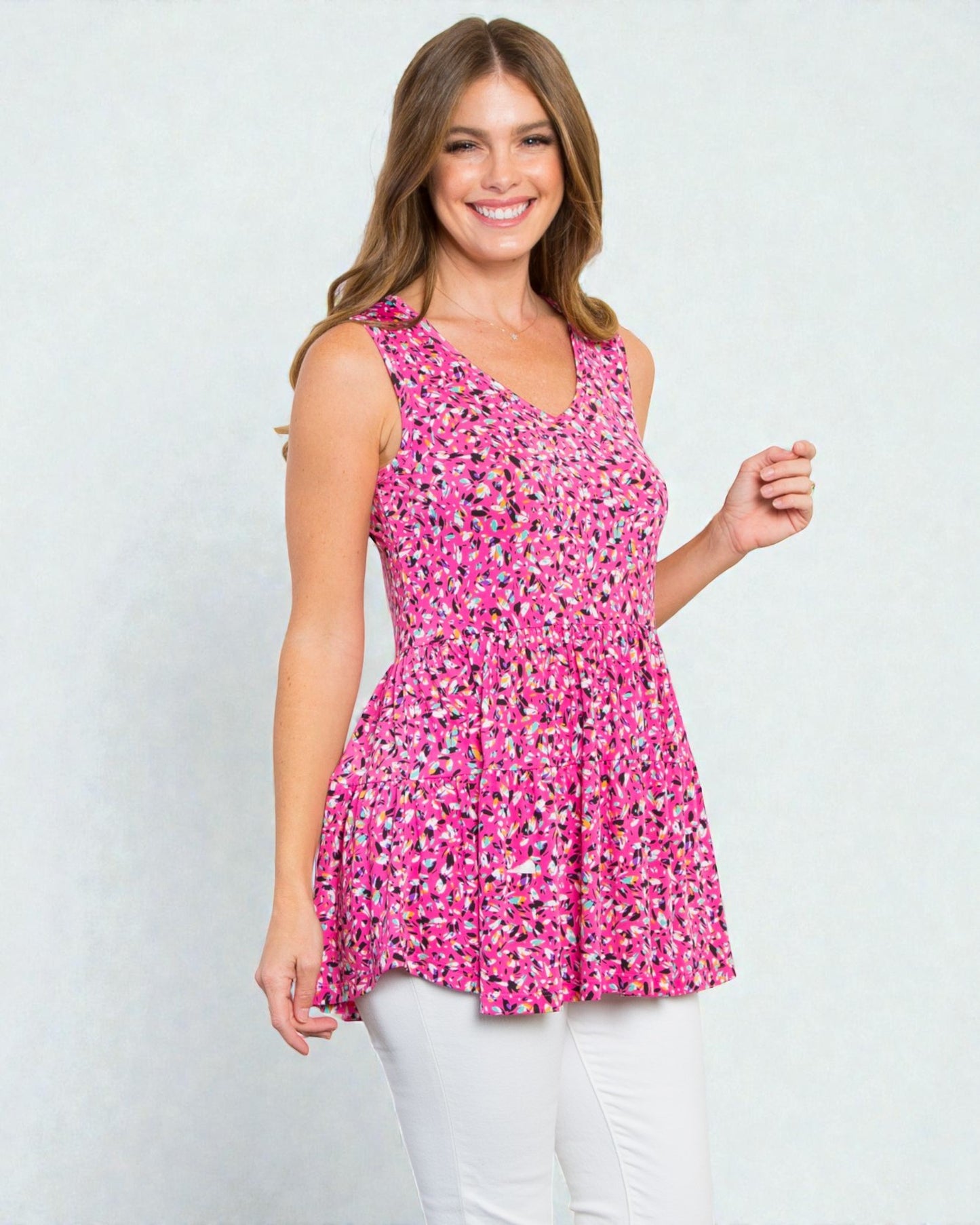 Woman wearing a pink floral sleeveless top against a white background