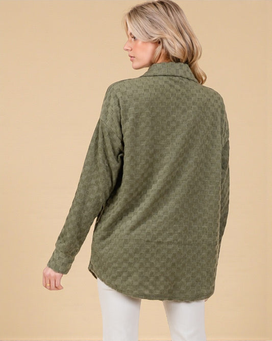 Woman wearing a green fleece jacket on a beige background