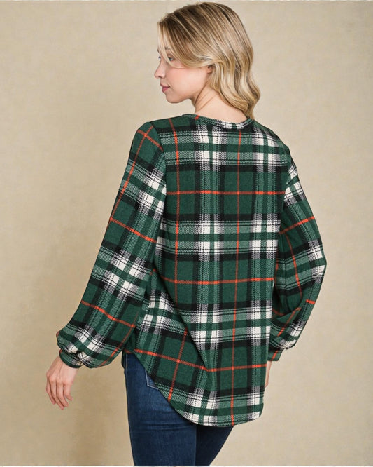 Woman wearing a green plaid shirt against a beige background