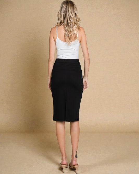 Woman wearing a white tank top and black skirt on a beige background