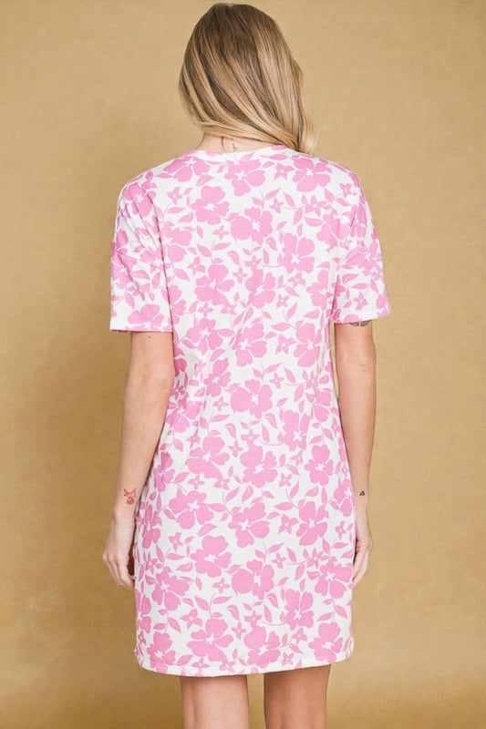 Person wearing a pink floral dress against a beige background
