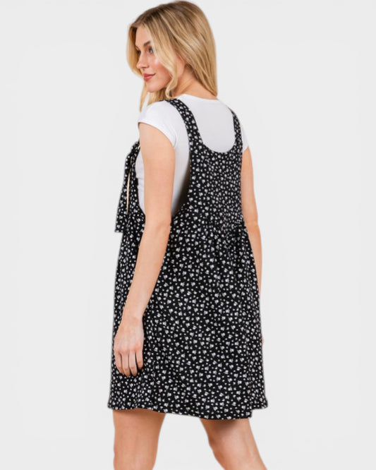 Woman wearing a black and white polka dot dress on a plain background