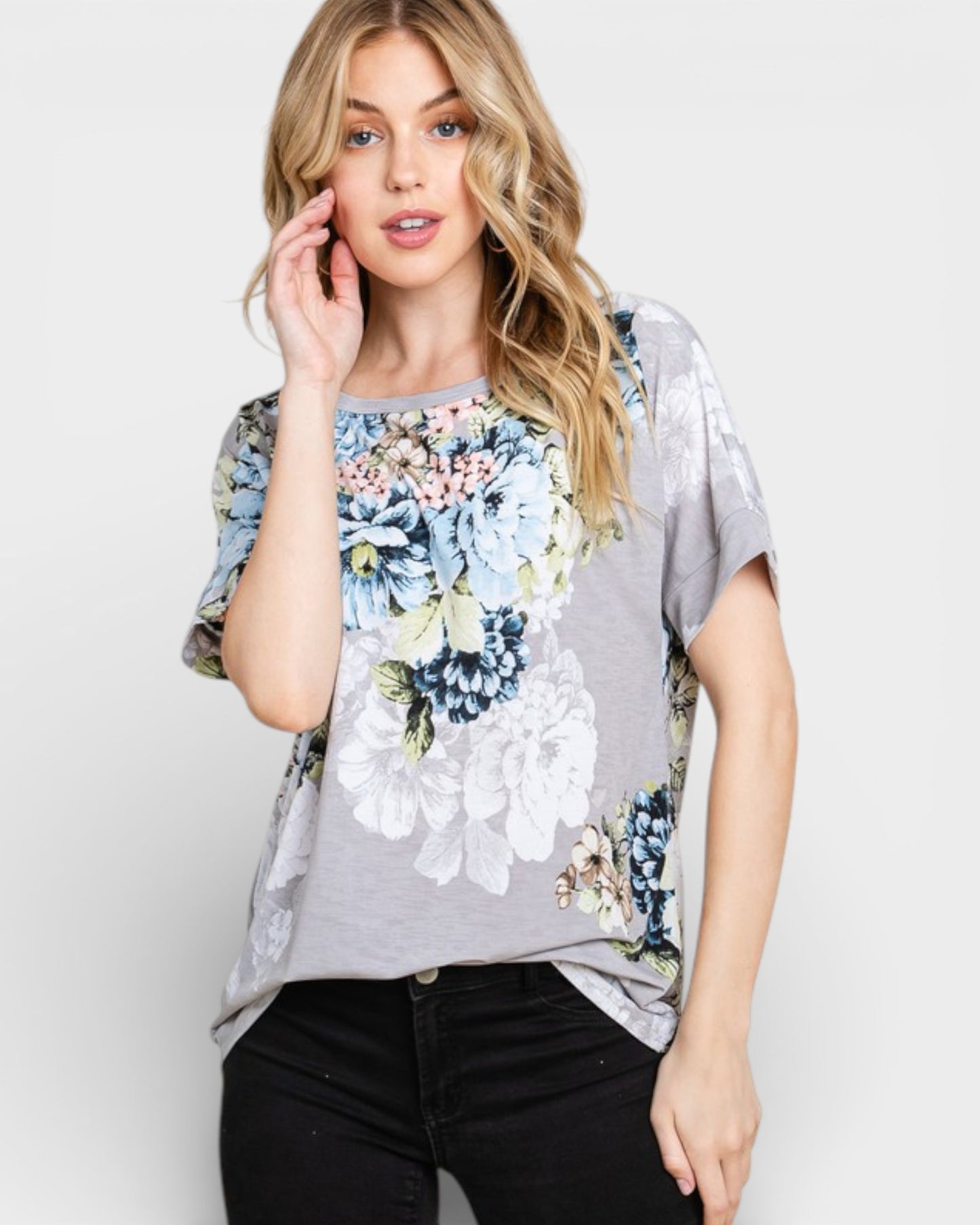 Woman wearing a gray t-shirt with floral patterns on a white background