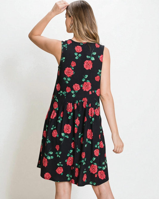 Woman wearing a black sleeveless dress with red rose pattern on a white background