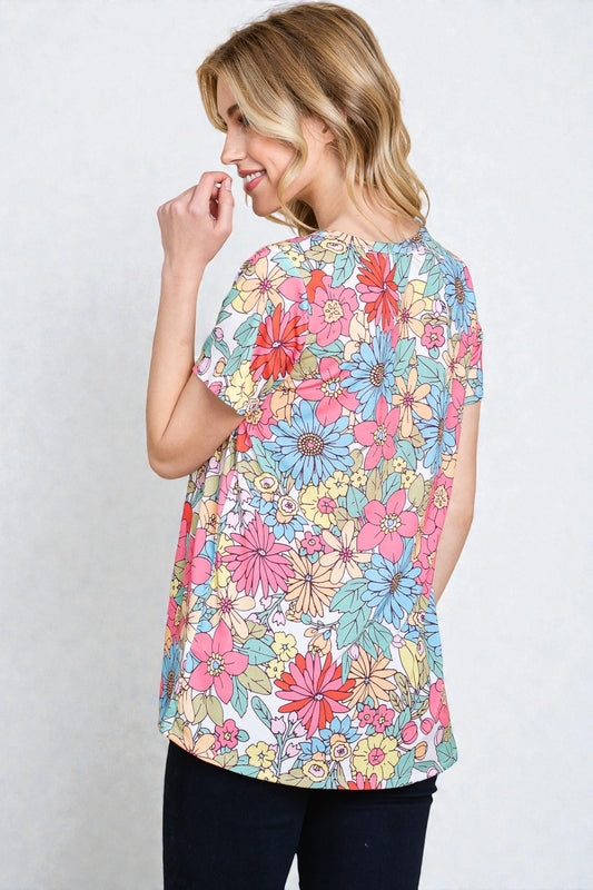 Woman wearing a colorful floral blouse against a white background