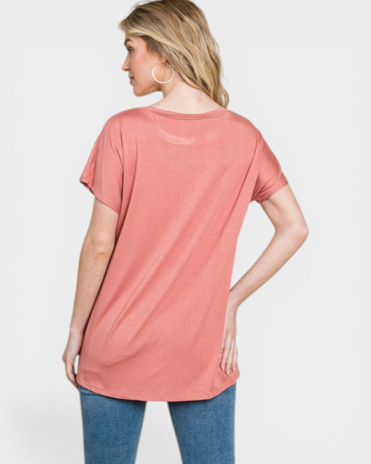 Woman wearing a pink t-shirt and blue jeans on a white background