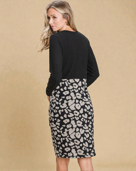 Woman wearing a black sweater and leopard print skirt against a beige background