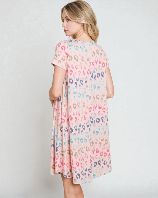 Woman wearing a pastel leopard print dress against a white background