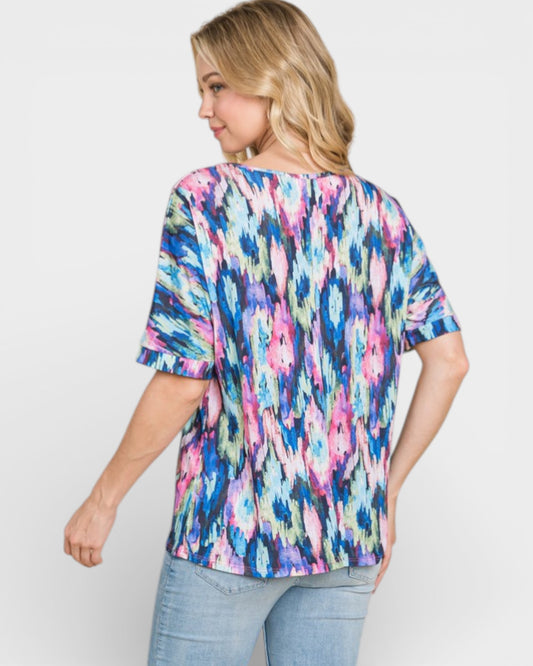 Woman wearing a colorful abstract patterned top on a white background