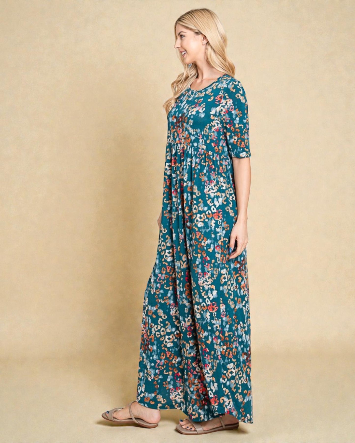 Woman wearing a long floral dress against a beige background