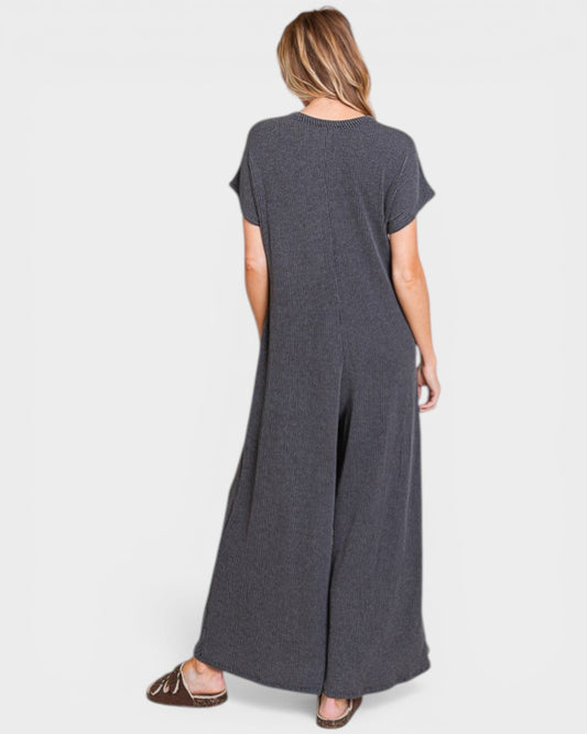 Person wearing a gray jumpsuit on a white background