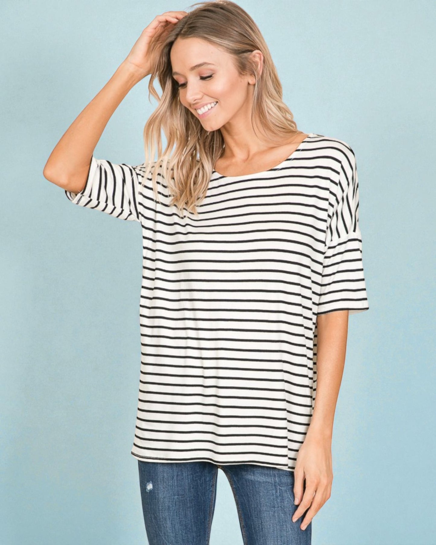 Woman wearing a black and white striped shirt against a light blue background