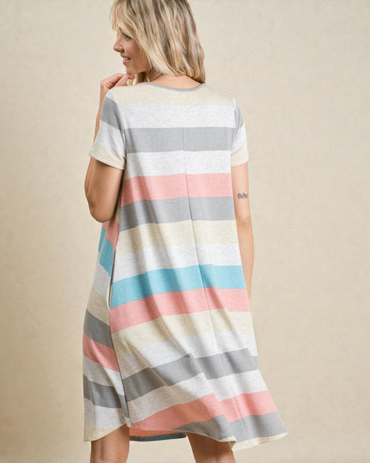 Woman wearing a striped dress with pastel colors on a beige background