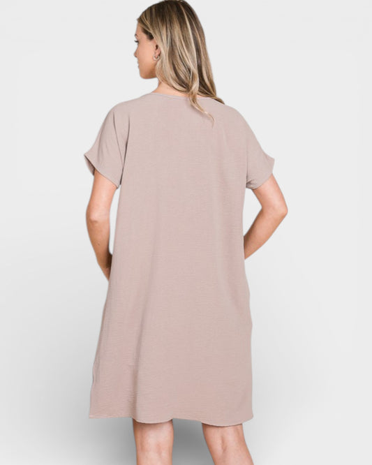 Woman wearing a beige dress on a white background