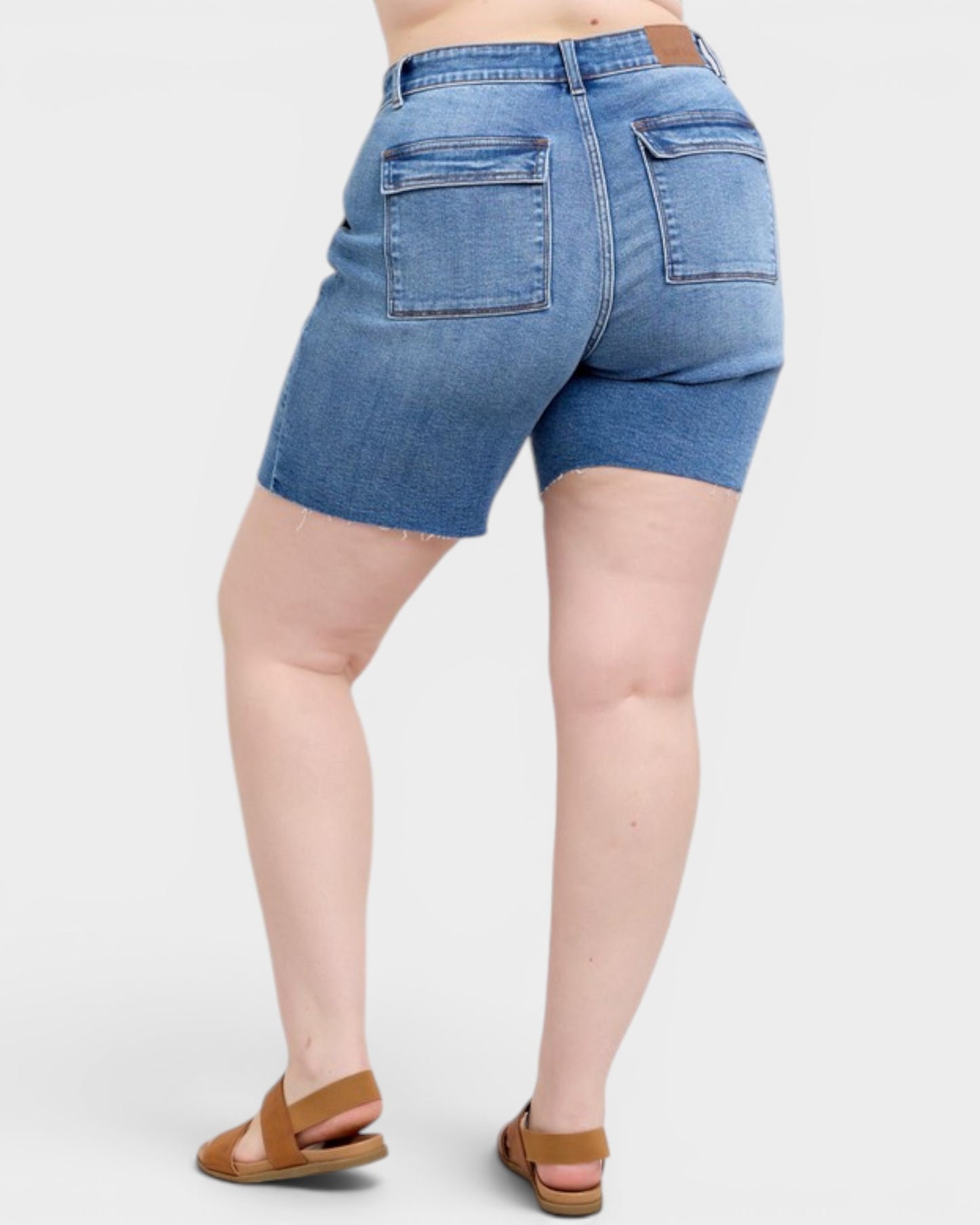 Blue denim shorts worn by a person on a white background