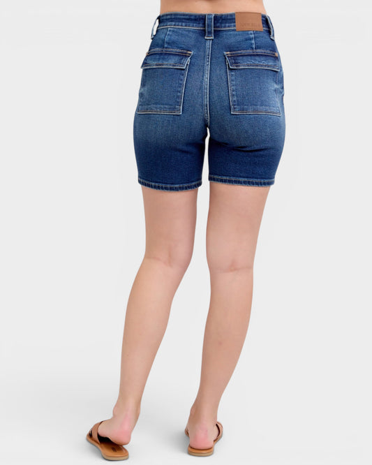 Blue denim shorts worn by a person on a white background