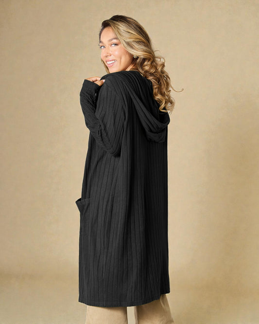 Woman wearing a black cardigan against a beige background