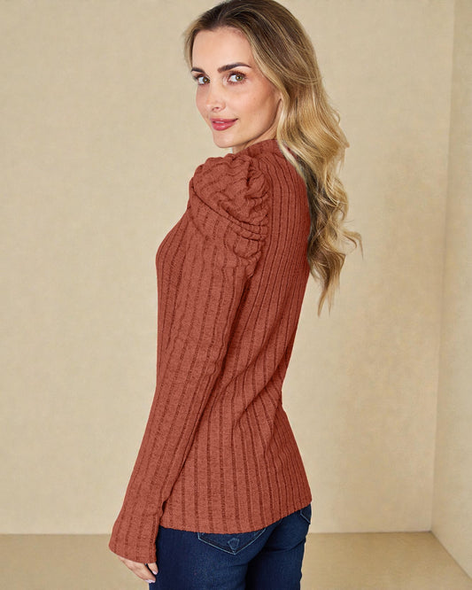 Woman wearing a rust-colored ribbed sweater against a beige background