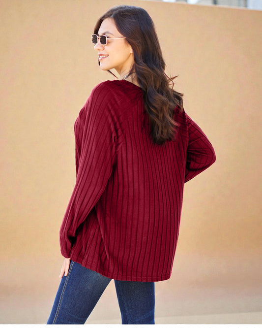 Woman wearing a red sweater and sunglasses against a beige background