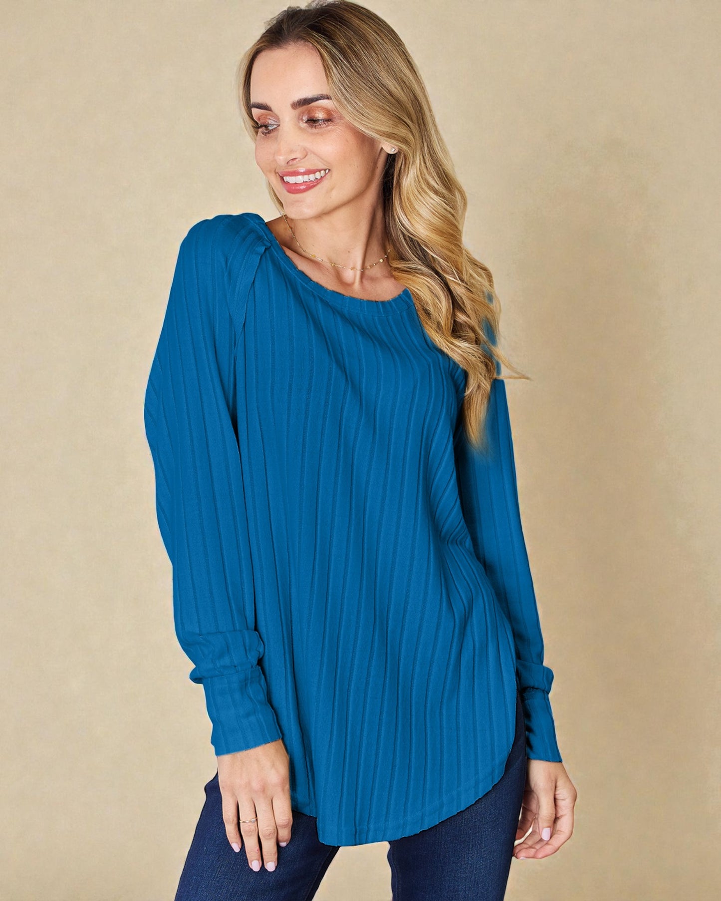 Woman wearing a blue sweater against a beige background