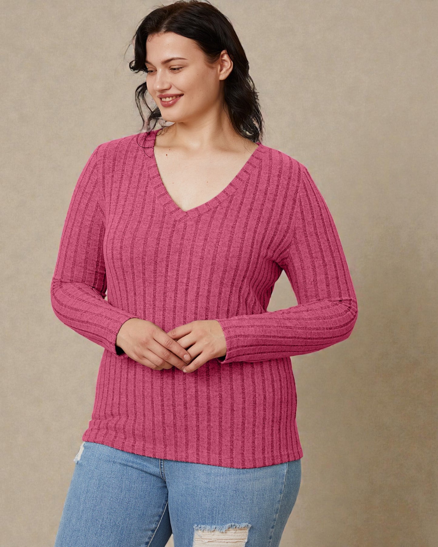 Woman wearing a pink ribbed sweater against a beige background