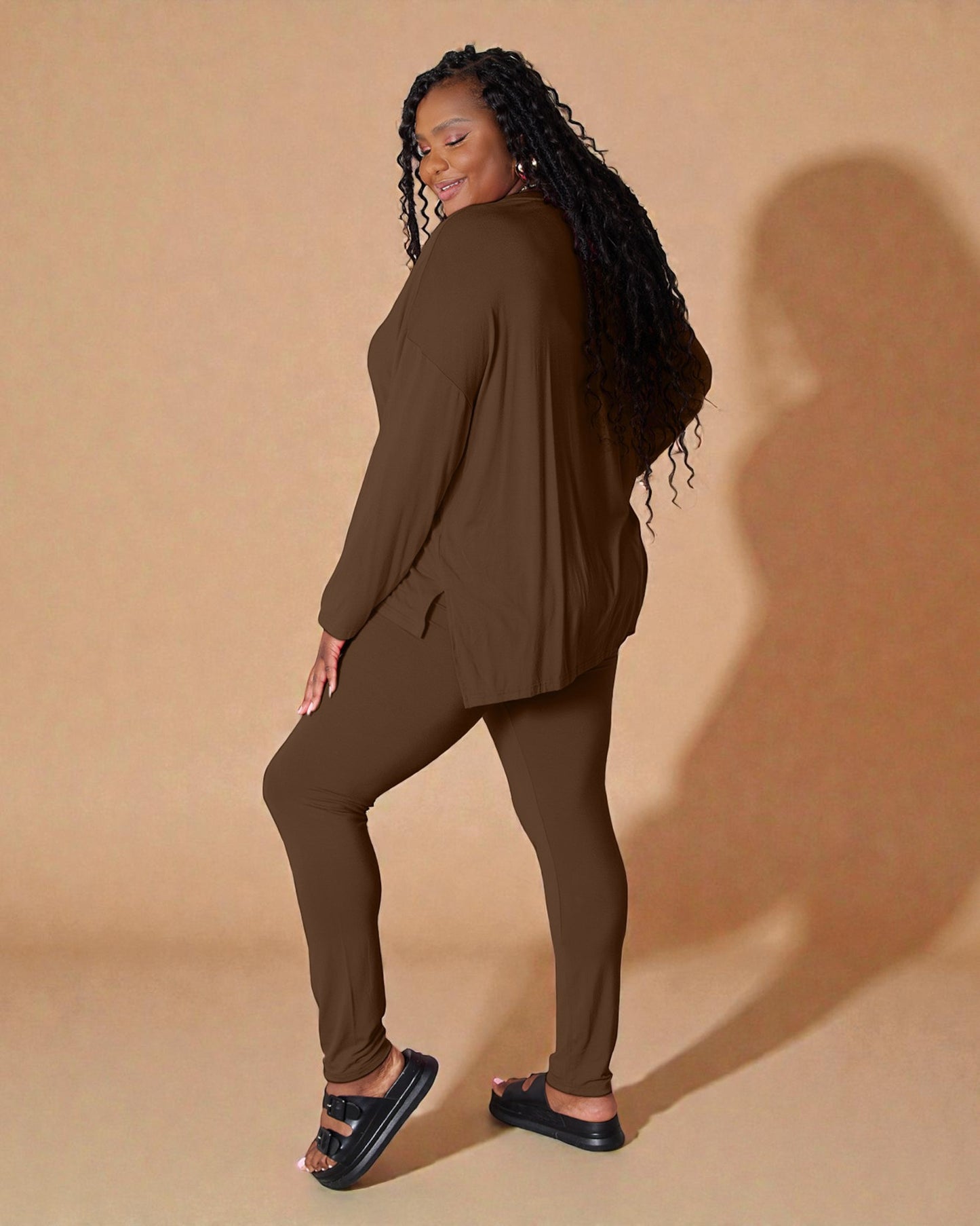 Woman wearing a brown outfit against a beige background