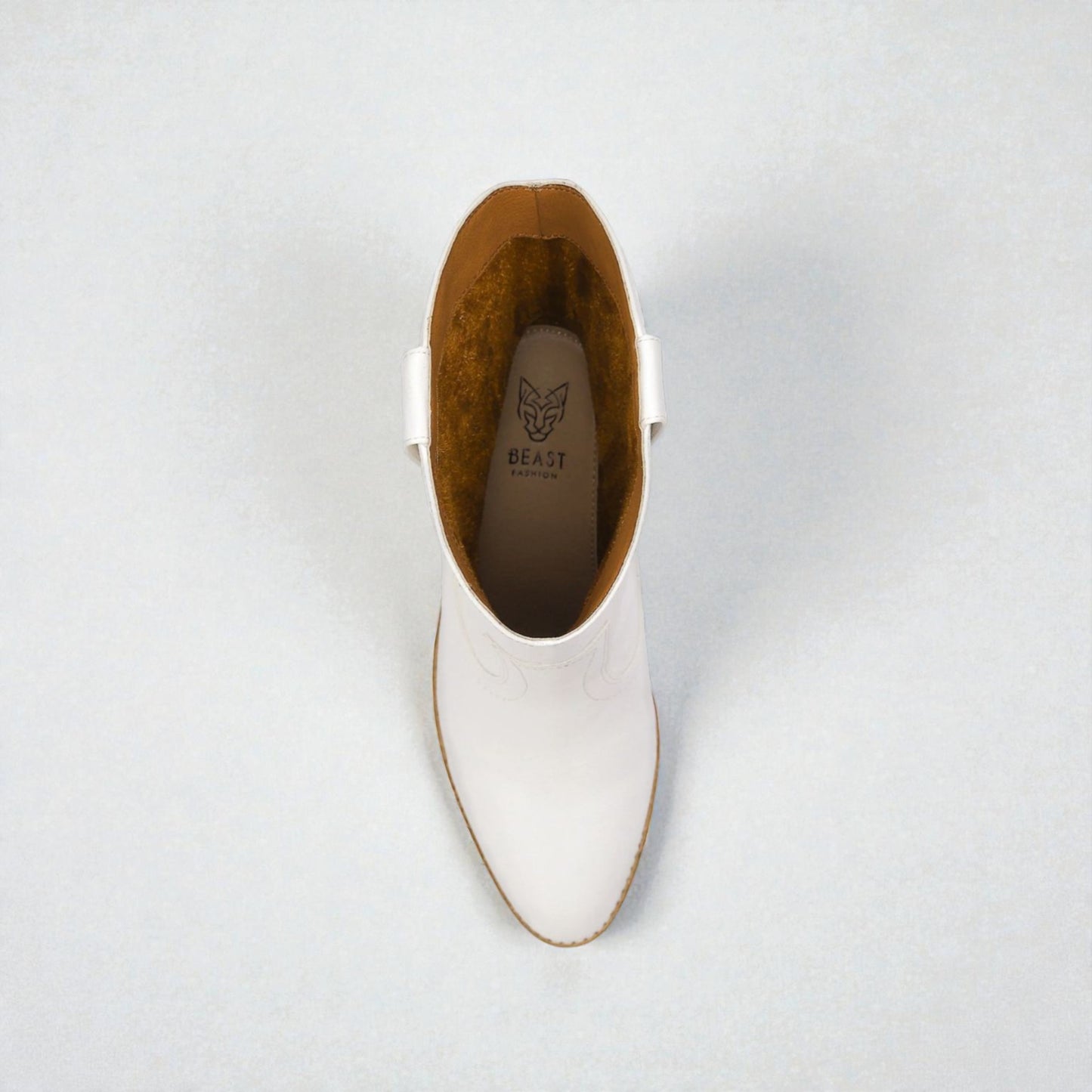 White ankle boot with brown lining on a light gray background
