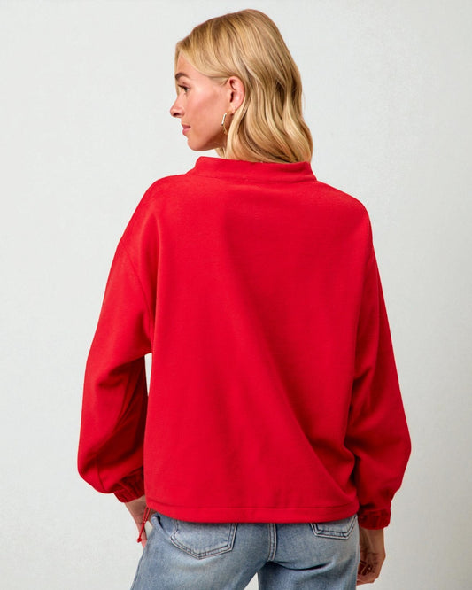 Person wearing a red sweatshirt with a plain background