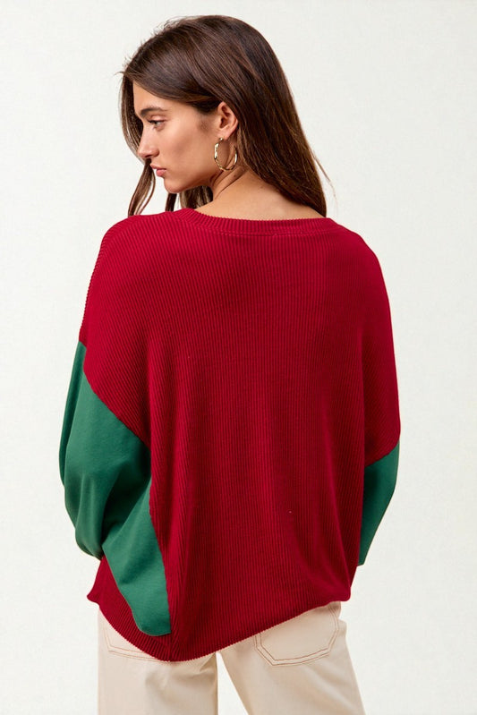 Woman wearing a red and green color-blocked sweater on a white background