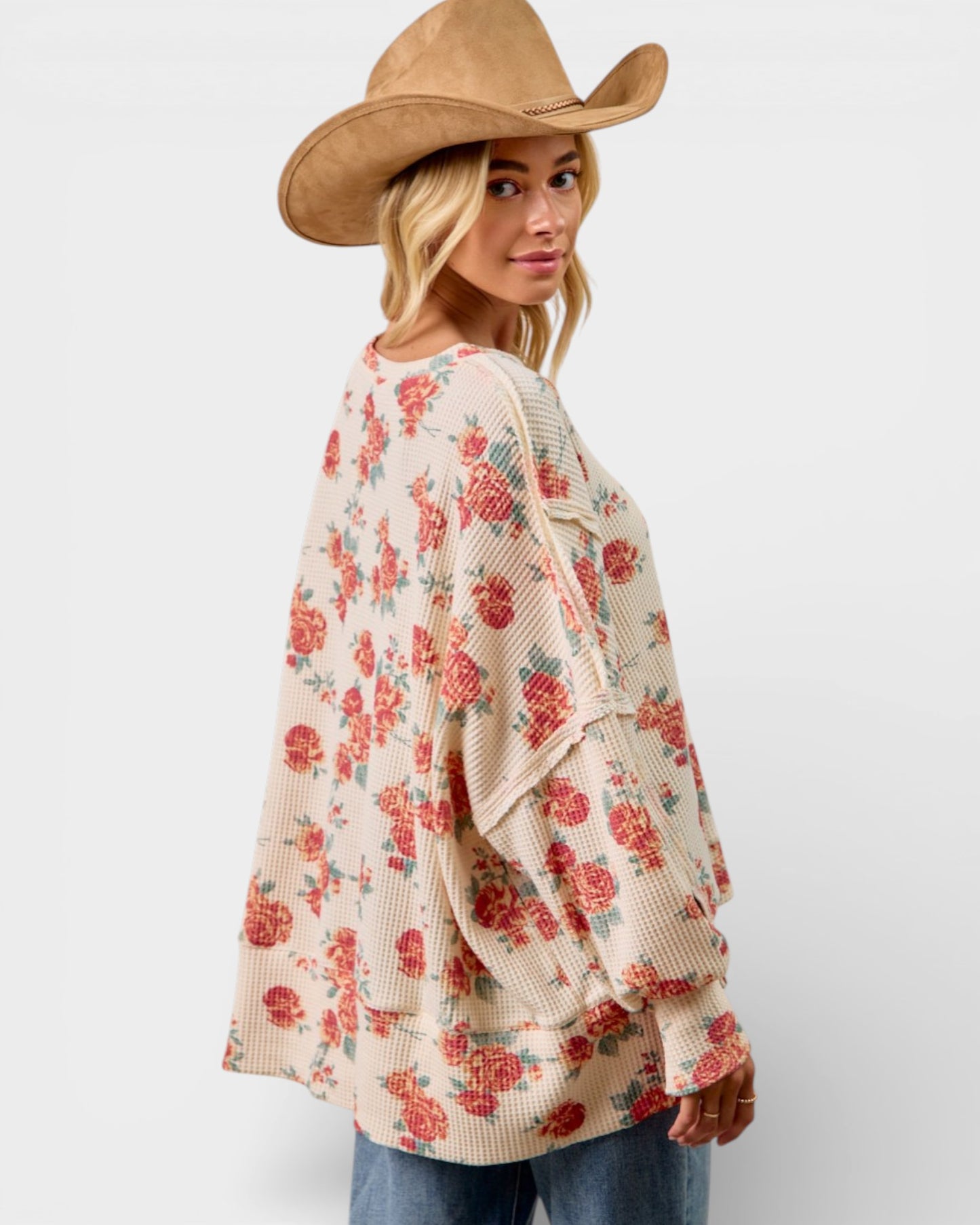 Woman wearing a floral cardigan and cowboy hat on a white background