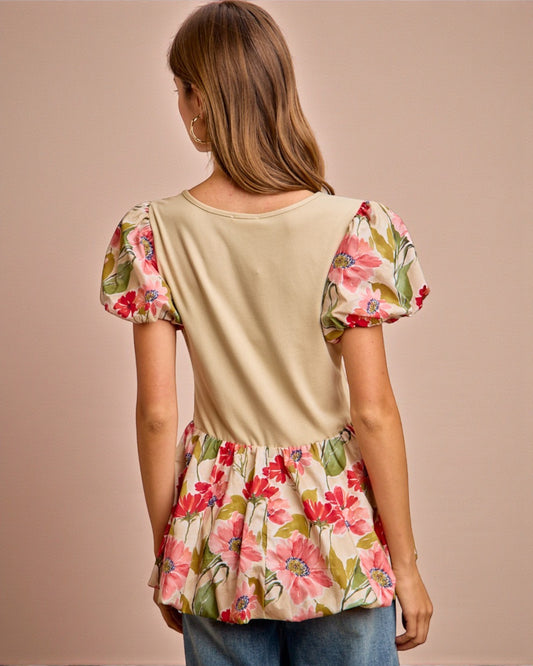 Woman wearing a beige top with floral sleeves and skirt on a beige background